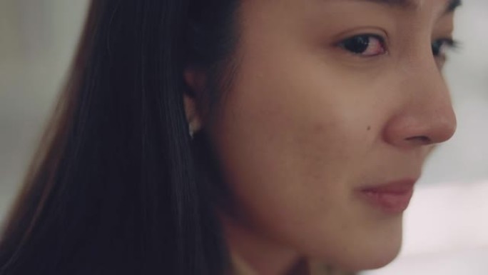 亚洲妇女在讲述自己的抑郁症时哭泣的特写镜头。
