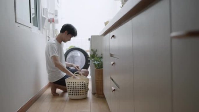 时髦的亚洲男子在家洗衣服