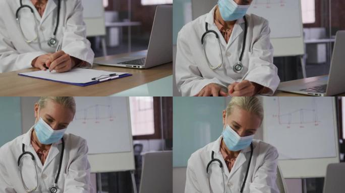 白人女医生戴着口罩坐在会议室的办公桌上做笔记