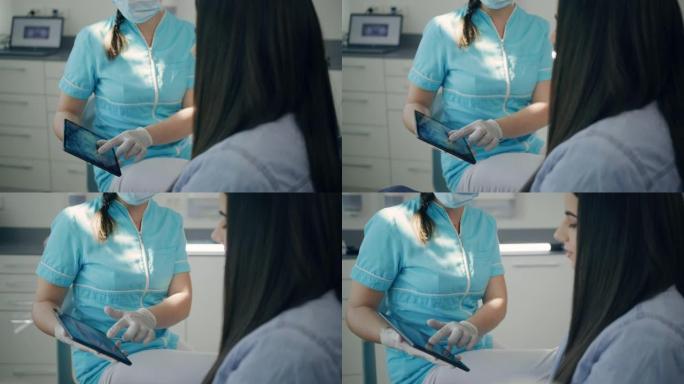 牙医女士向女性患者解释了数字平板电脑上的x射线扫描