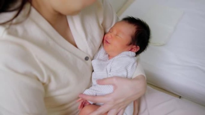 特写妈妈抱着熟睡的新生婴儿。保险人寿、护理、保障