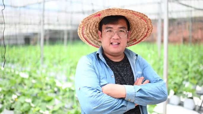 亚洲中国微笑的男性农民的肖像，检查他的有机农场生长