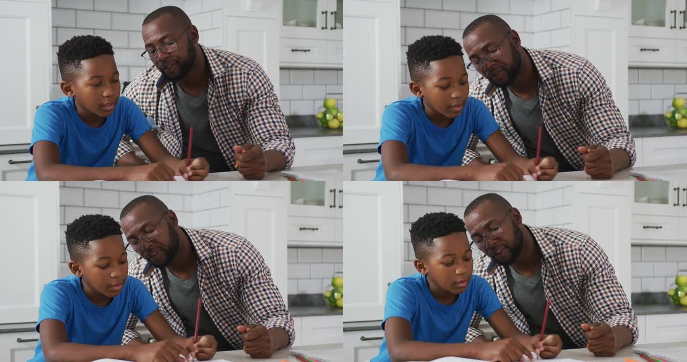 非裔美国人父亲坐在厨房的桌子上，帮助儿子完成学业
