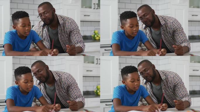 非裔美国人父亲坐在厨房的桌子上，帮助儿子完成学业