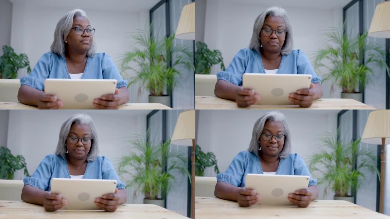 体贴的成熟黑人女性在家看着远处，然后看着平板电脑