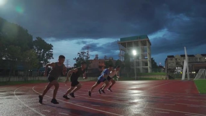 慢动作亚洲中国男运动员在男子跑道上下雨，深夜在体育场用泛光灯奔跑