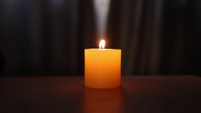 桌子上的单个发光蜡烛