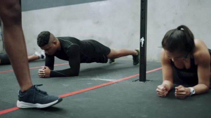 一名健身教练指导一群运动的年轻人在健身房拼板的4k视频片段