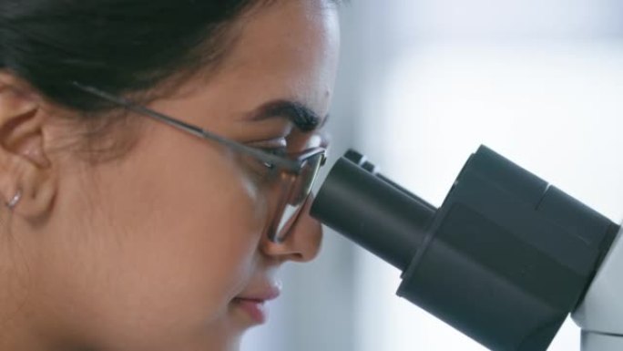 卫生保健科学家在实验室用显微镜进行dna、rna和医学研究。特写女制药生物学家研究人类细胞，药物和生