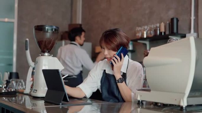 女服务员用智能手机与顾客交谈。