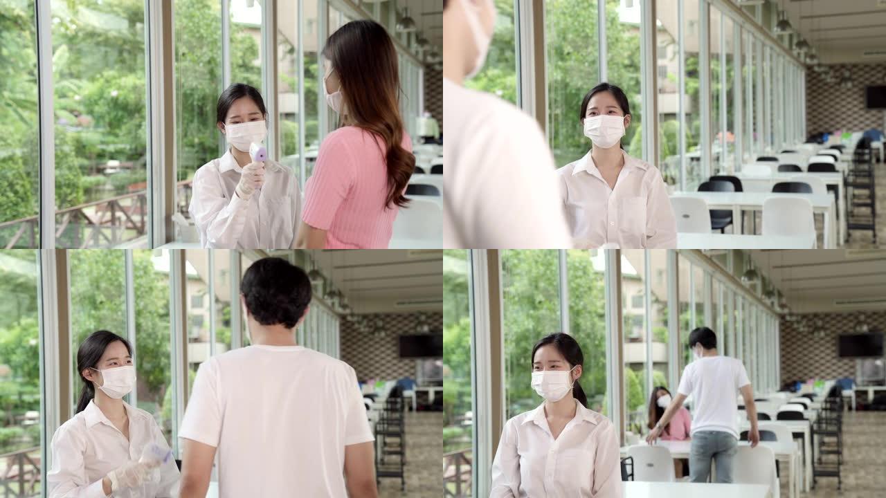 4K UHD多莉镜头: 女服务员在进餐厅前给顾客量体温。corovirus大流行后新的正常生活方式概