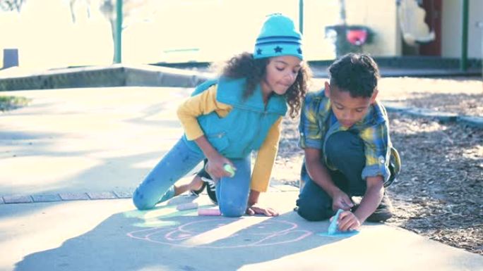 多种族儿童在人行道上用粉笔画画
