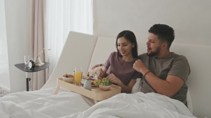 拉丁夫妇在床上一起吃早餐