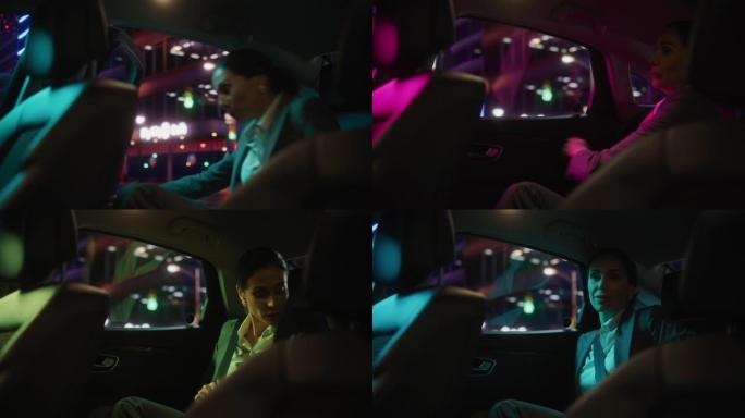 成功的女商人正在坐在她的豪华车的后座上，并在晚上系安全带。企业家乘客在城市街道上乘坐带有工作霓虹灯的