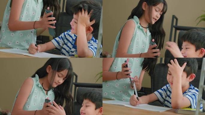 特写姐姐在手机上展示作业教学哥哥做作业。家庭教育概念。家庭学校