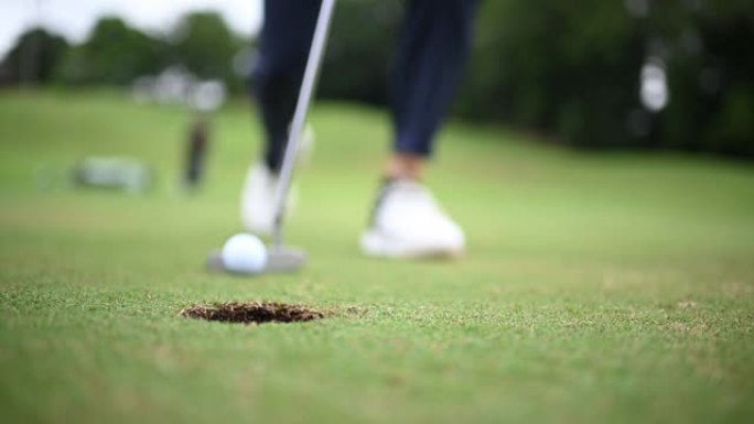 亚洲中国男高尔夫球手在高尔夫球场上的高尔夫球洞轻拍慢动作特写