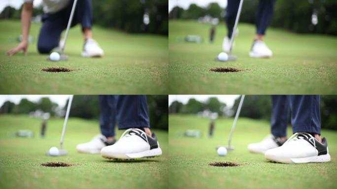 亚洲中国男高尔夫球手在高尔夫球场上的高尔夫球洞轻拍慢动作特写