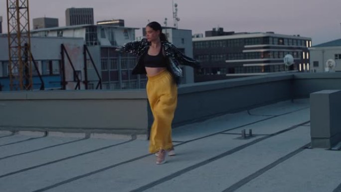 美丽的女人在屋顶上跳舞，年轻的巴西女人在日落时在城市表演拉丁舞动作