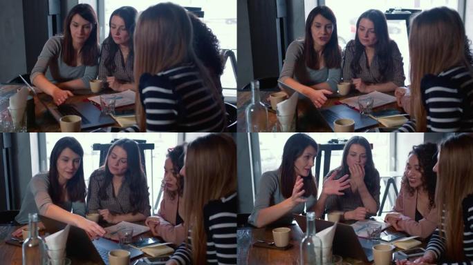 团队合作和合作理念。年轻的高加索女老板使用笔记本电脑与咖啡馆的同事一起工作。