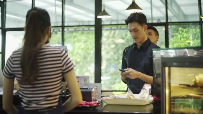 亚洲中国年轻女性收银员在面包店咖啡厅的商品价格