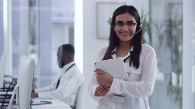 4k视频片段，一名年轻的女商人站在办公室并戴着耳机使用数字平板电脑