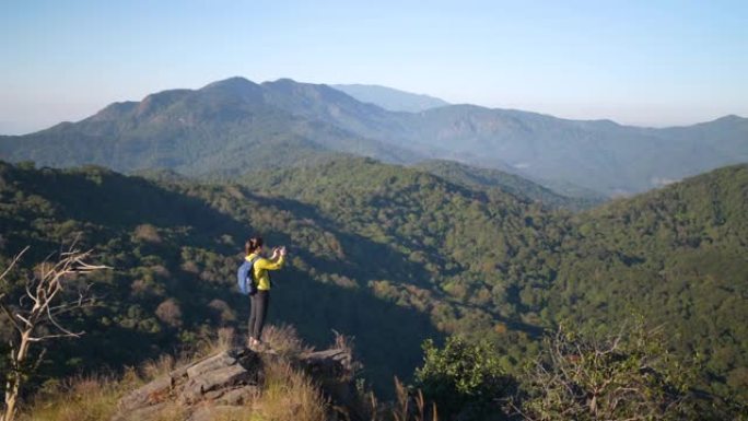 女旅行者徒步上山拍照