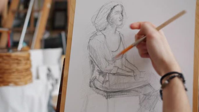 在艺术学校上课期间，男人的手素描女人的肖像特写