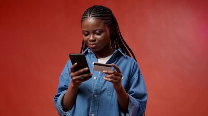 一位年轻的黑皮肤学生正在智能手机中购买她非常想要的东西，并感到高兴