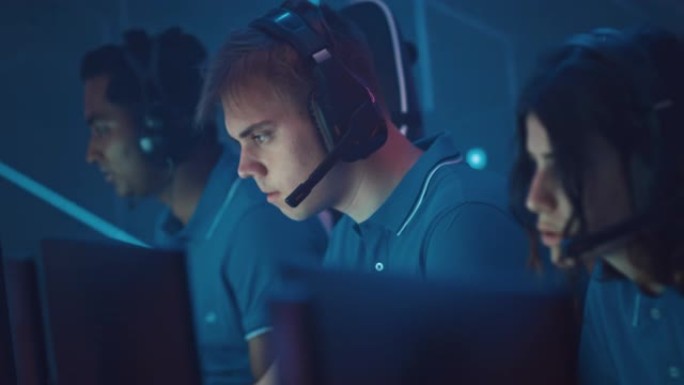 专业游戏玩家玩电脑视频游戏，与队友在锦标赛上与头戴式耳机交谈。专业游戏玩家的多元化Esport团队在