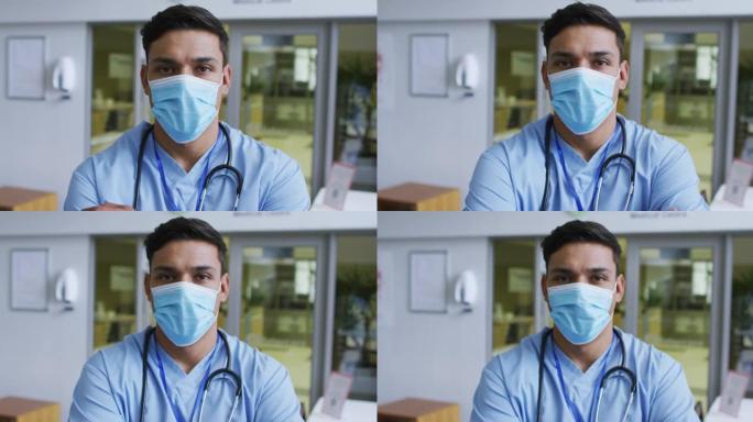 混血男医生戴着磨砂膏和口罩站在医院的肖像