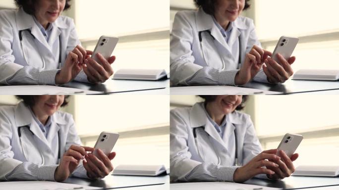 年长的女医生拿着智能手机打字给病人