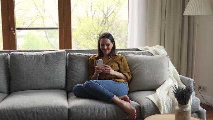 女少年在沙发上休息，与男友使用智能手机联网