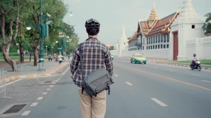 年轻人带着他值得信赖的踏板车在曼谷旅行。