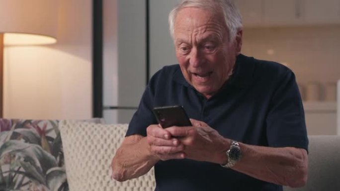 一名高级男性在家中使用手机庆祝的4k视频片段