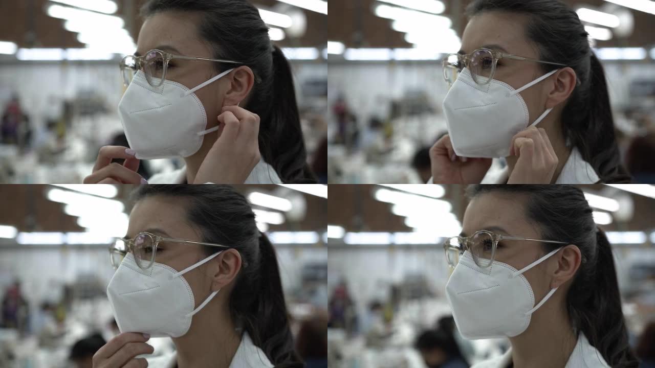 年轻女子在纺织厂调整防护口罩