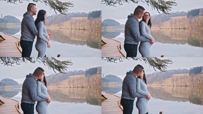 中年男子在看着河时亲吻他怀孕的妻子