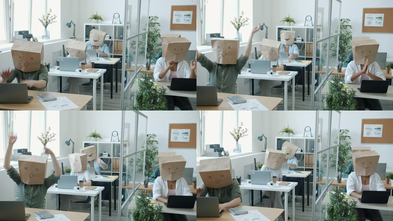 男、女员工头上装着纸袋忙于办公室活动，表达情绪