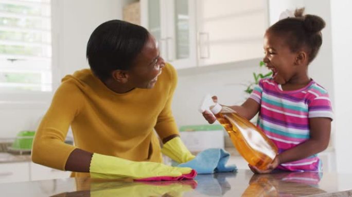 非裔美国母亲和女儿清洁台面并在厨房大笑