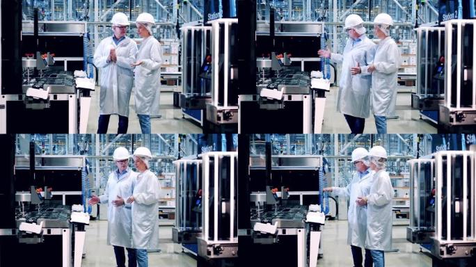 两名专家正在太阳能电池工厂观察机器。工程师，团队合作，现代化工厂设施。