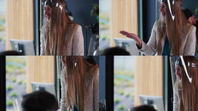 在办公室领导团队会议上，年轻快乐的千禧一代金发女老板穿着新型冠状病毒肺炎面罩的肖像。
