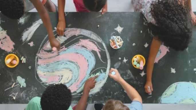 有趣，有创意和教育意义的孩子在教室里画画活动，老师在平板电脑上拍照。儿童自愿参加一个丰富多彩的艺术项