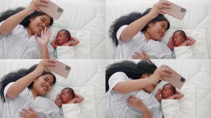 新生婴儿和新手妈妈用智能手机相机微笑着自拍