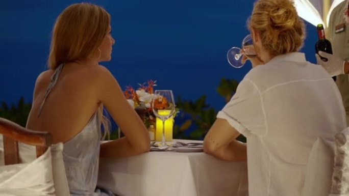 服务员一边倒酒，同时25岁的白人白人美丽夫妇在庆祝情人节时浪漫约会。情人节cocnept。