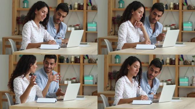 年轻的西班牙裔夫妇同事员工通过笔记本电脑开发共同项目