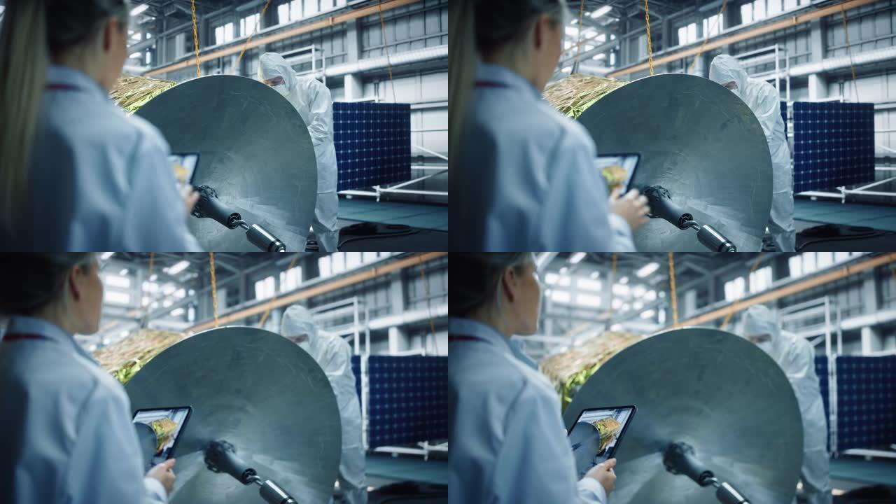 女工程师在进行卫星建设时使用数字平板电脑。航空航天局: 科学家为太空探索任务组装航天器。超过肩膀射击