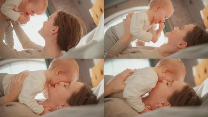 快乐的妈妈和一个可爱的新生婴儿玩耍。妈妈和一个蹒跚学步的孩子在一起，抱着她的上方，亲吻婴儿的脸颊。童