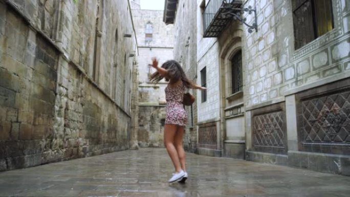 4k视频录像一位迷人的年轻女子在西班牙度假期间在雨中玩耍