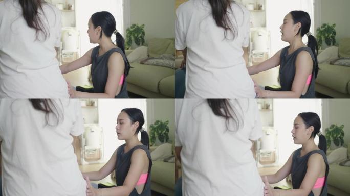 年轻的女瑜伽教练在家为孕妇教授瑜伽。