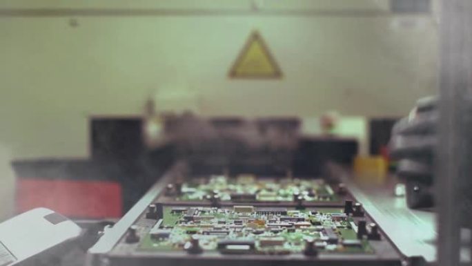 在计算机制造厂，工人手握条形码扫描仪在有烟的印刷电路板上。特写。4k分辨率。