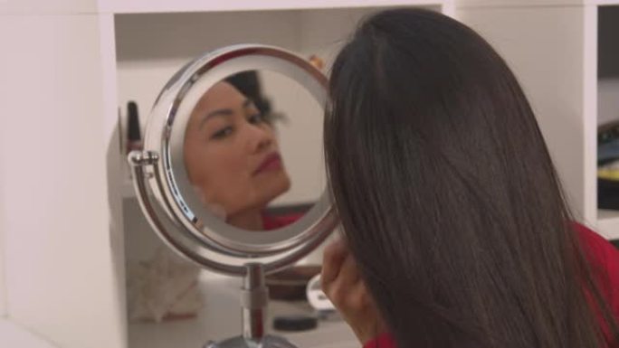 特写: 使用刮痧刮刀的漂亮女人在化妆镜中的反射